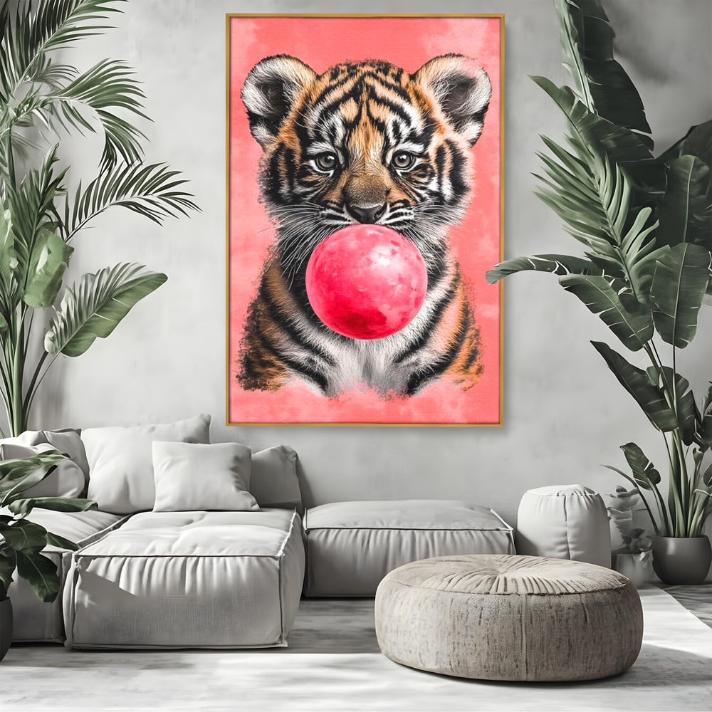 Tablou canvas cu ilustratie pui de tigru cu guma roz, in rama de aluminiu auriu, pe perete intr-un living